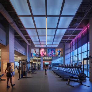 a vibrant, modern gym interior features diverse individuals engaging in high-energy workouts surrounded by sleek fitness equipment and motivational posters, encapsulating the dynamic atmosphere of a fitness community.