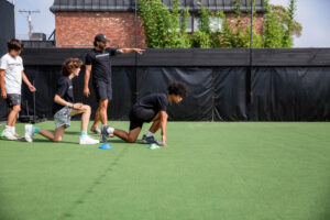 small group of adults performing strength training exercises together in a bright, well-equipped fitness studio